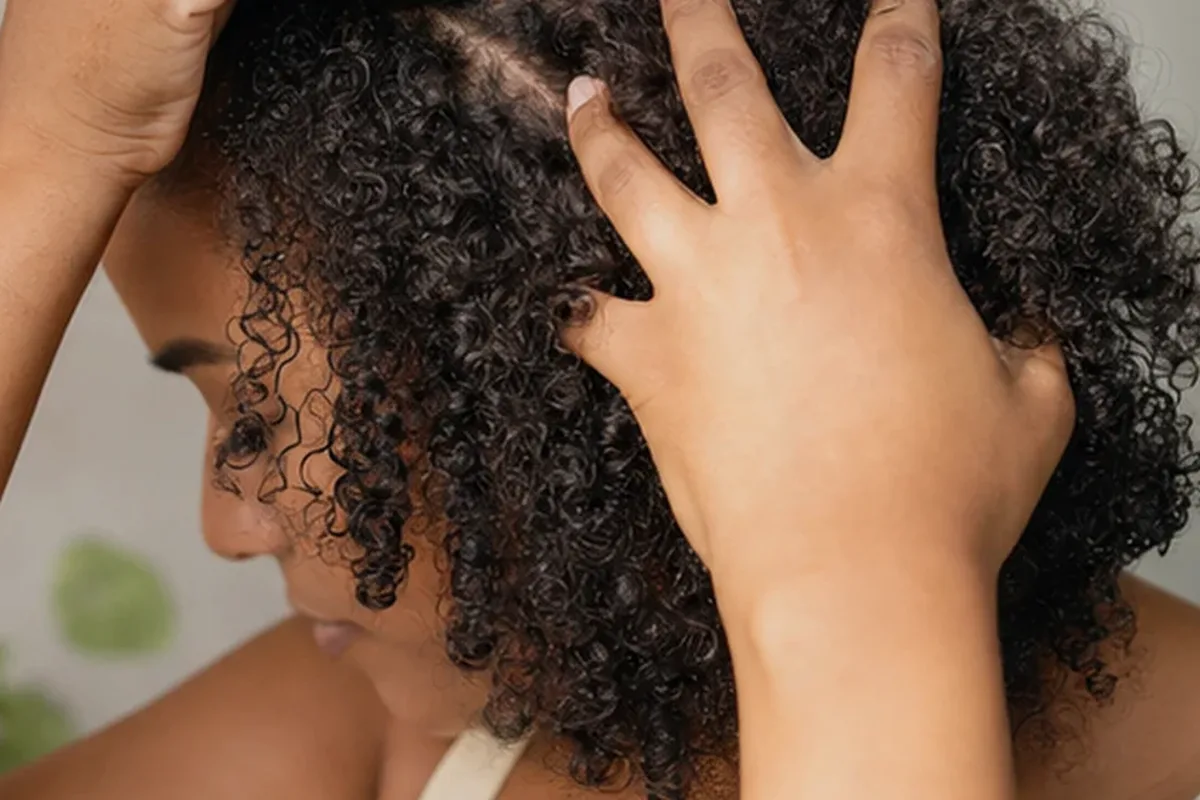 Emotionaler und authentischer Anwendungsmoment rund um Hitzeschutz für lockiges Haar